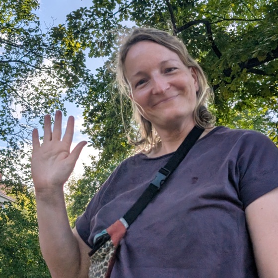 Julia Friesel waving under a tree